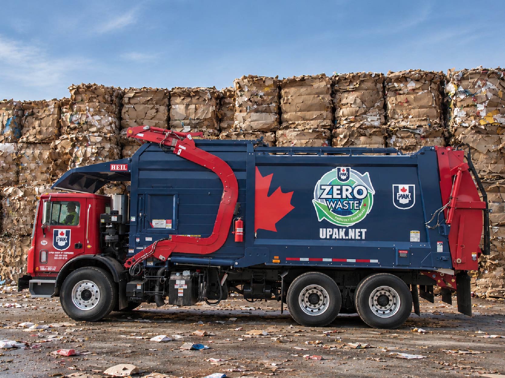 U-Pak truck in front of piles of cardboard recycling boxes. U-Pak front-end truck. U-Pak provides optimized commercial waste management solutions to businesses in the GTA.